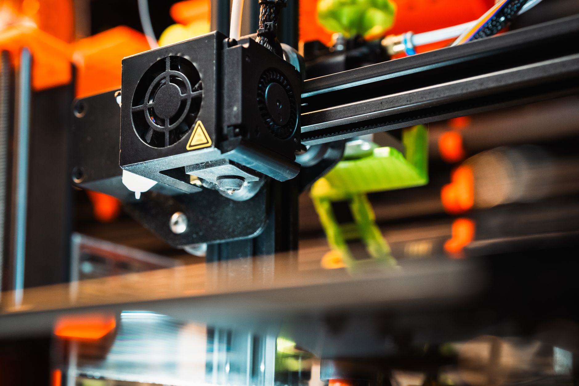 Person wiping a 3D printer build plate with a microfiber cloth