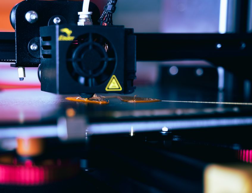 Colorful 3D printed cookie cutters and small planters on a table