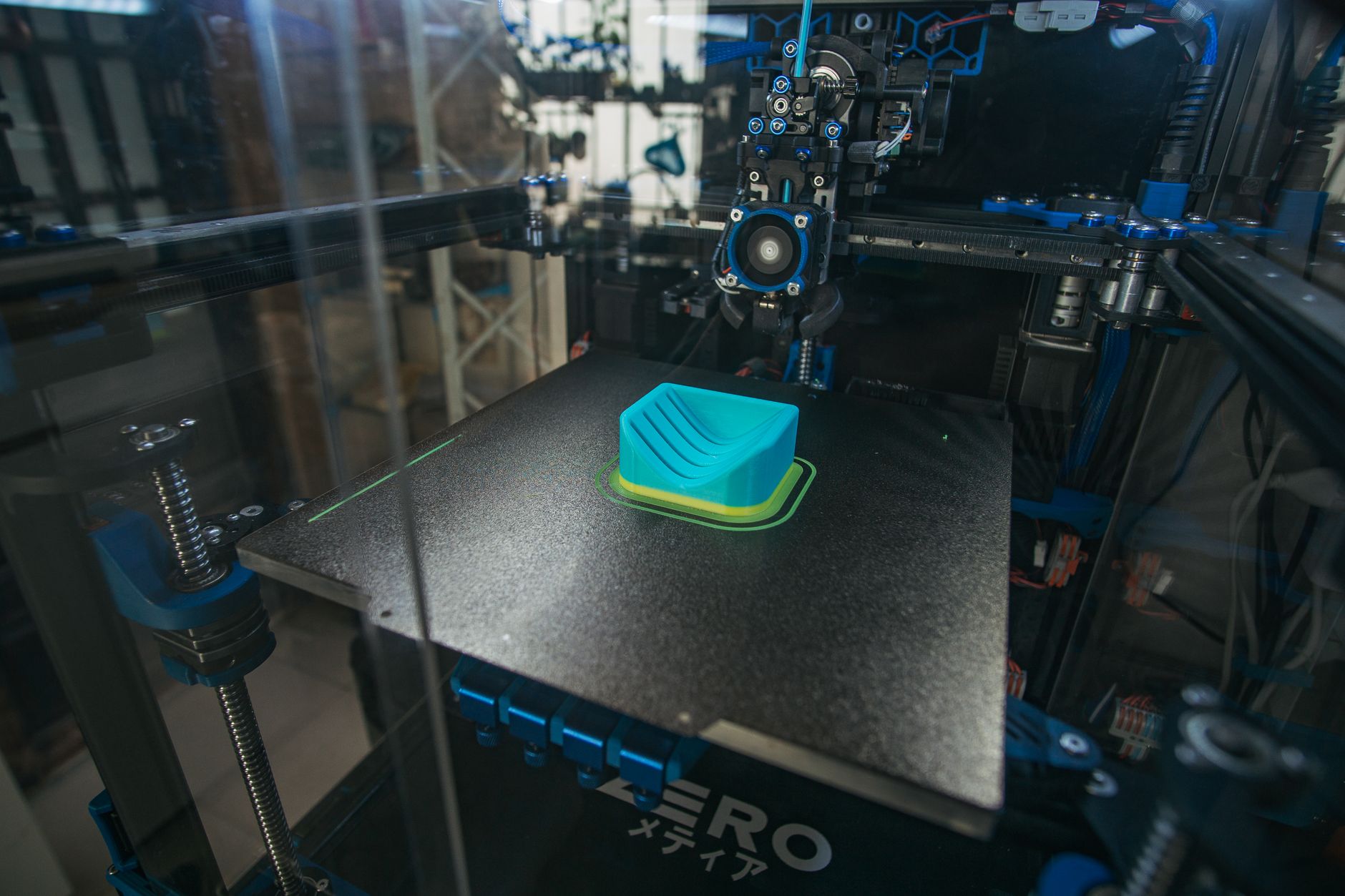 Resin 3D printer creating dental model next to finished aligner molds