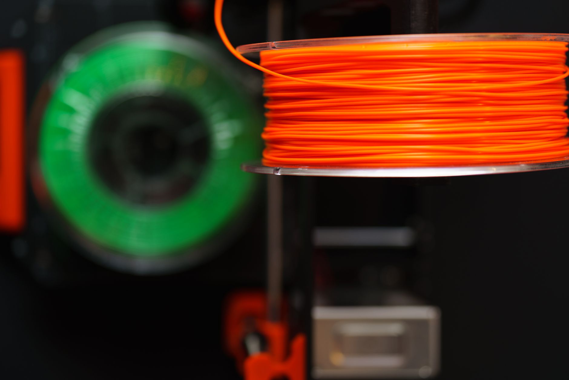 Cardboard spool of white 3D printer filament on 3D printer