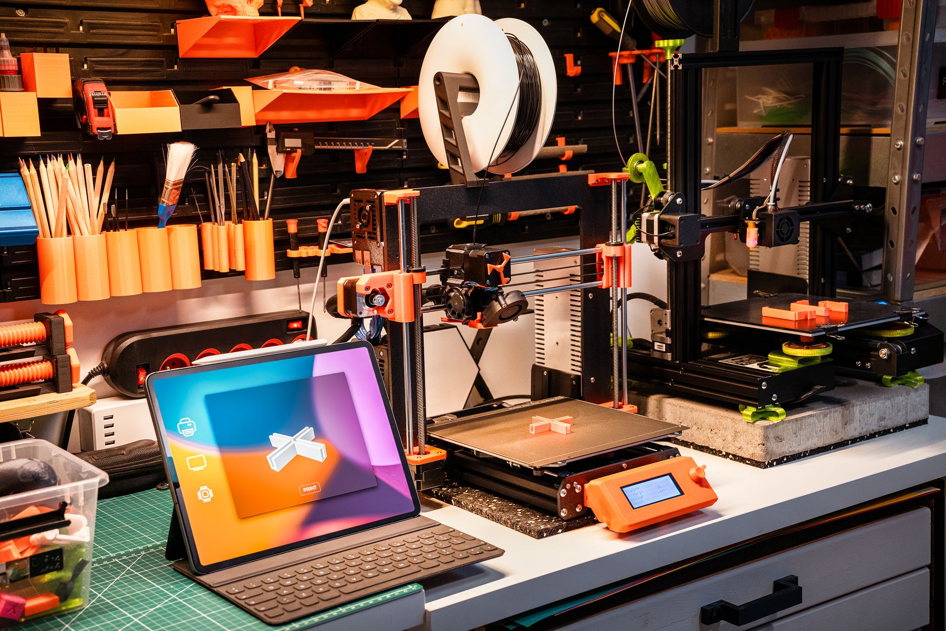 Small orange open source 3D printer on a clean workbench
