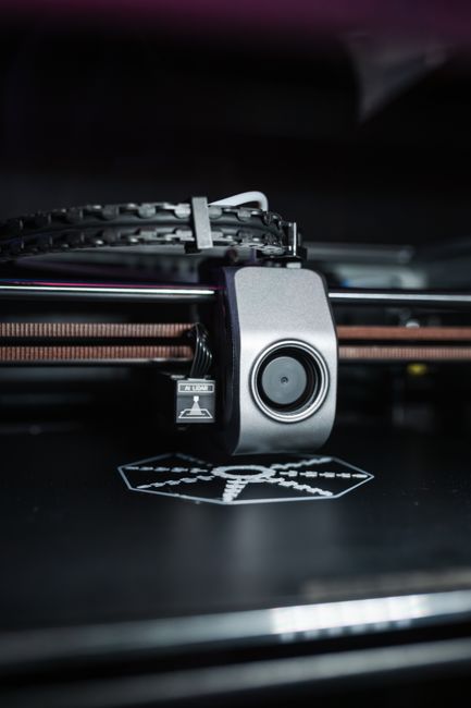 Enclosed 3D printer printing a white ABS part inside a closed chamber