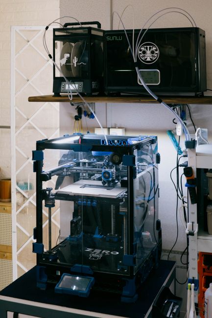3D printer producing a detailed orange model on a print bed